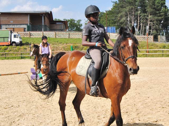 Enfant apprenant à faire du cheval 