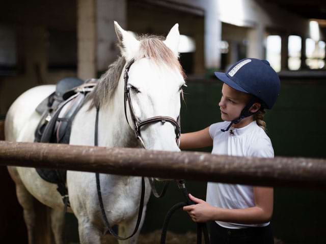 Portrait d'un enfant et son cheval au centre équestre