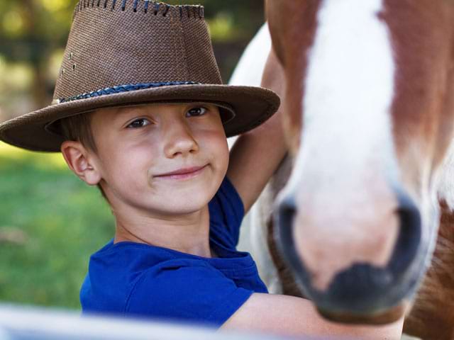 Enfant avec son cheval en stage sportif