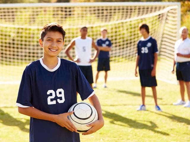 Adolescents jouant au football en stage sportif 