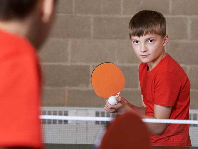 Enfant pratiquant le ping pong 