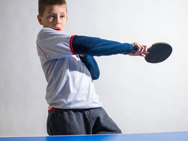 Enfant jouant au tennis de table en stage