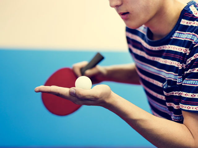 Adolescents apprenant à servir au tennis de table en colo