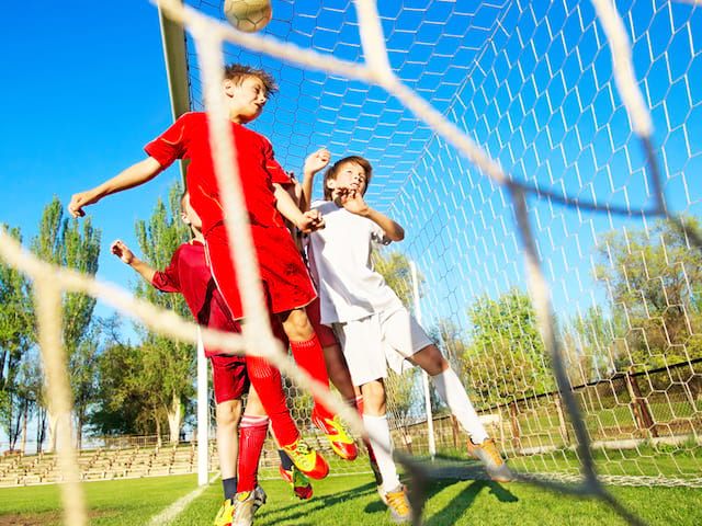 Ados jouant au football en stage