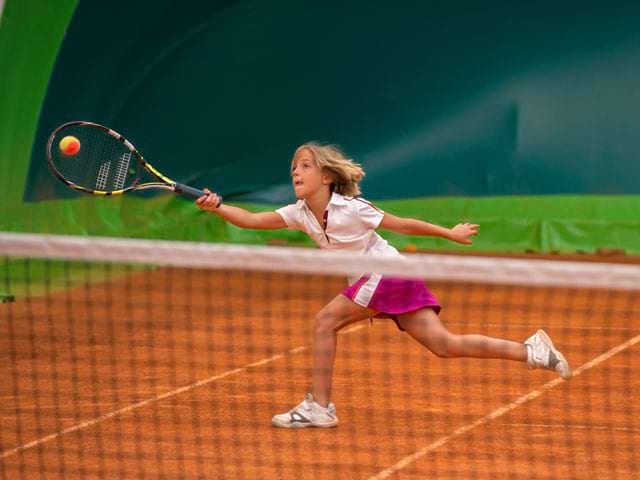 Jeune fille jouant au tennis en stage sportif