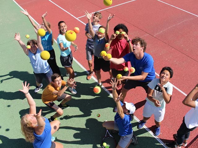 Groupe d'ados s'amusant avec des balles de tennis