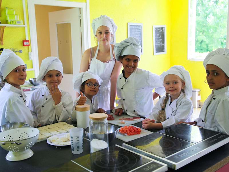 groupe d'enfants en train de cuisiner en colonie de vacance ce printemps