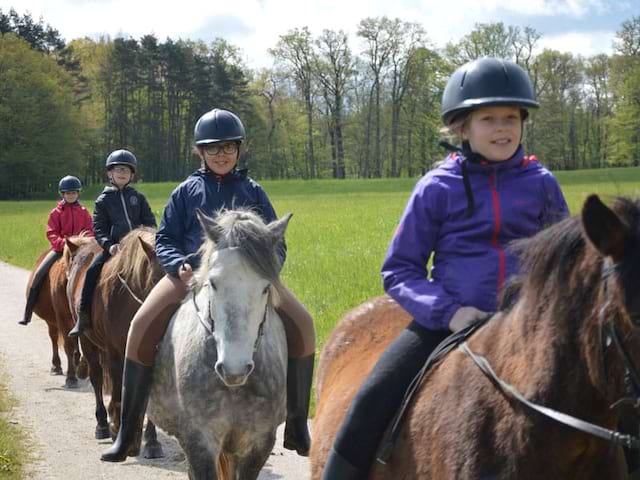 groupe d'enfants en randonnée à cheval en colonie de vacances pour apprendre l'anglais en France