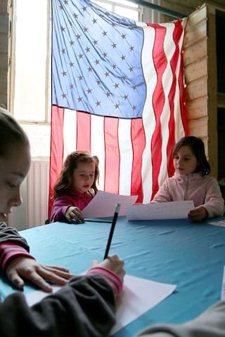 Enfants autour d'une table de classe en colonie de vacances pour apprendre l'anglais en France