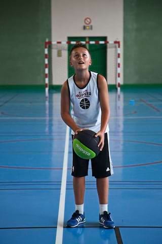 Jeune preado preparant son lancer durant une partie de basketball en colonie de vacances multisports au printemps