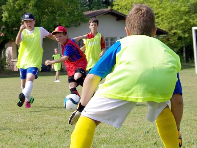 enfant occupant le role de gardien de but au football en colonie de vacances multisports au printemps