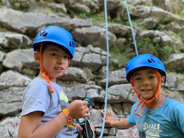 Deux garçons faisant de l'escalade en colo ce printemps