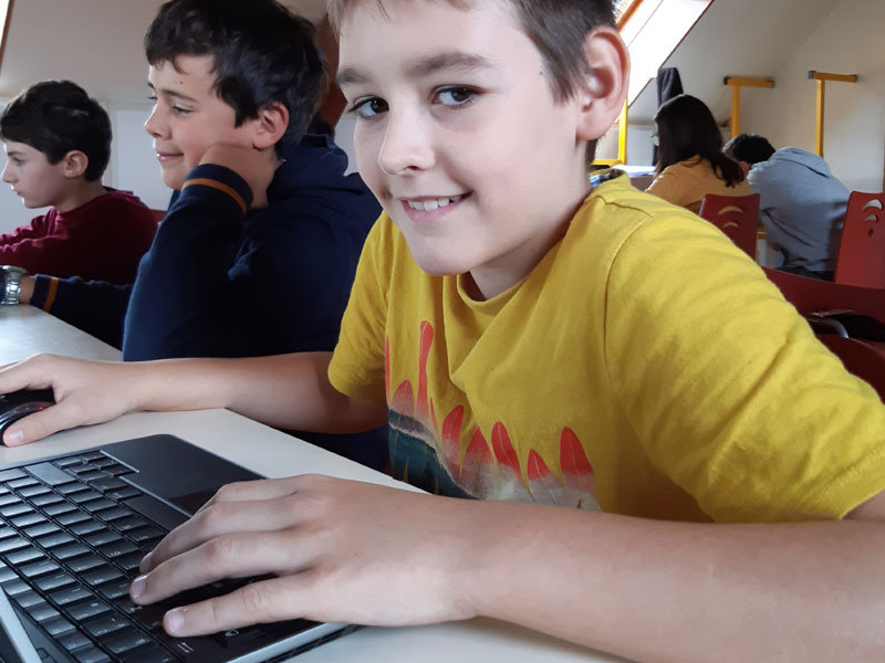 Enfant de 11 ans apprenant à coder sur un ordinateur en colonie de vacances de printemps