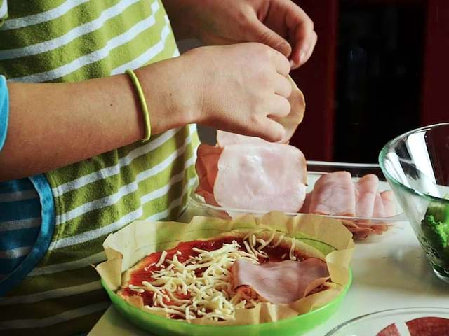 enfant cuisinant une tarte en colonie de vacances ce printemps