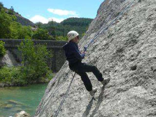 Un enfant en pleine activité escalade descends en rappel