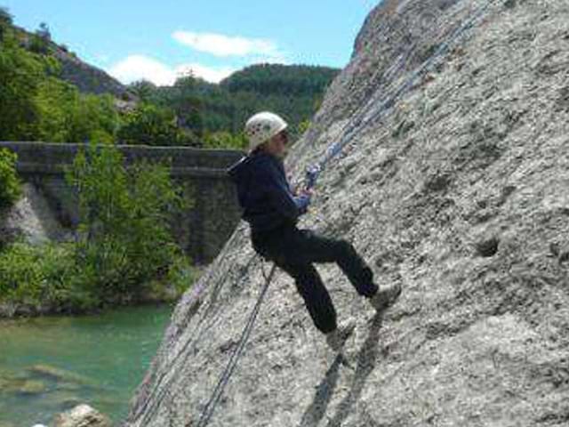 Un enfant en pleine activité escalade descends en rappel