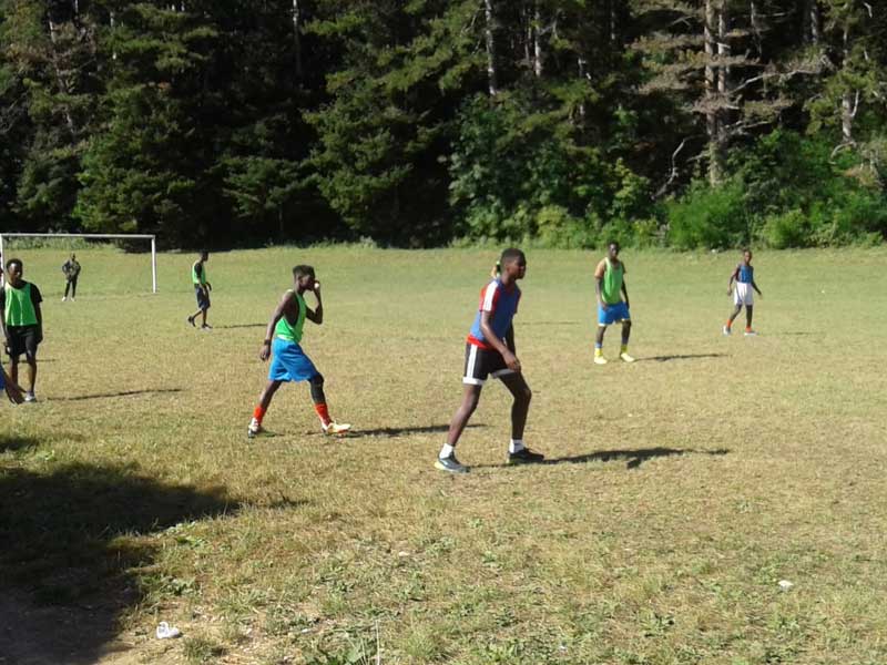 Groupe d'adolescent faisant un entraînement de foot dans un gymnase