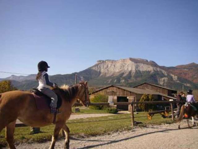 Enfants faisant une balade à cheval en colonie de vacances au printemps