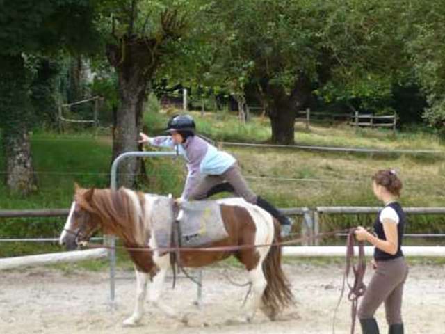 Enfant faisant de la voltige sur un cheval en colonie de vacances