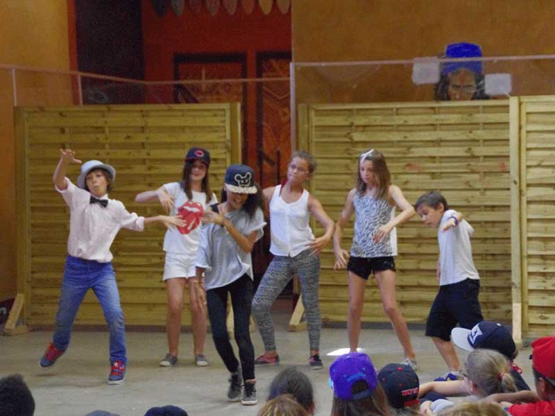 Groupe d'enfants faisant un spectacle de danse devant la colonie de vacances au printemps