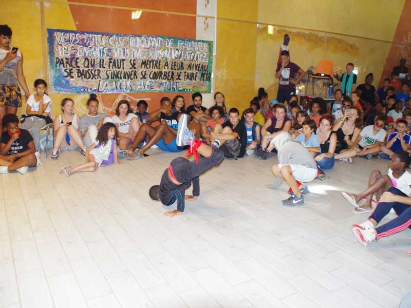 groupe d'enfants faisant des figures de danse devant la colonie de vacances