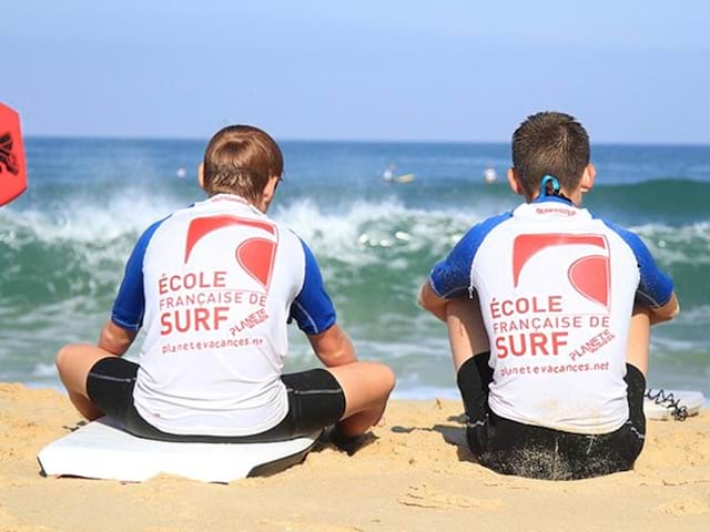 ados de dos en bord d'ocean en cours de surf en colonie de vacances printemps