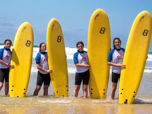 Groupe d'ados avec leur planche de surf en colo ce printemps