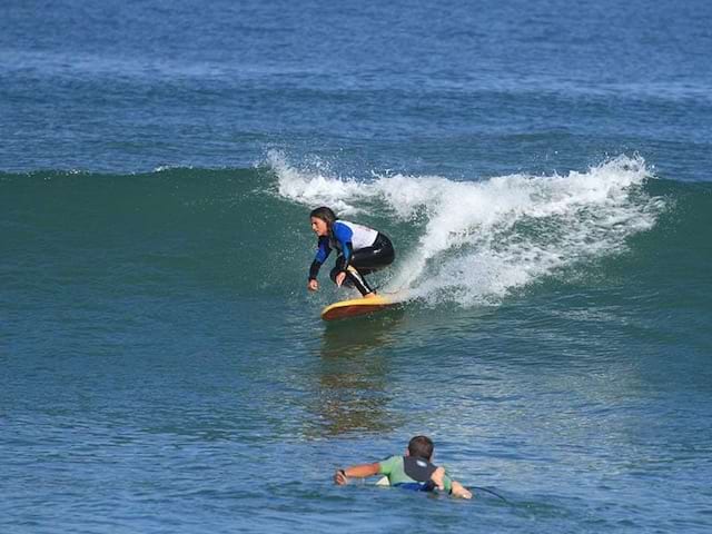 enfants apprenant à faire du surf en colonie de vacances au printemps