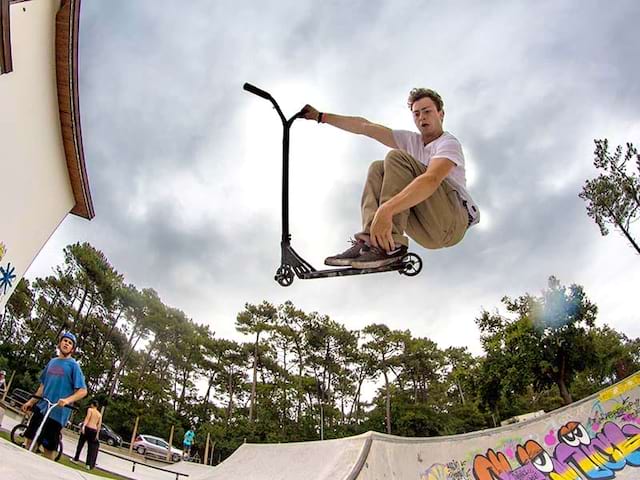 adolescent faisant un saut en trottinette en colo ce printemps