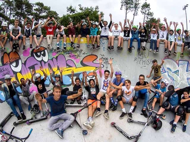 groupe d'enfants en colonie de vacances faisant de la trottinette