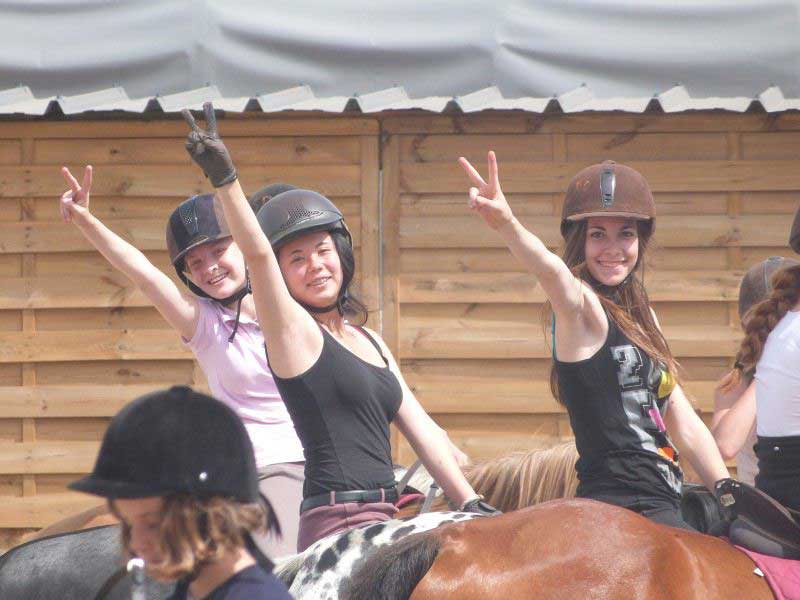 groupe de jeunes filles à cheval en colonie de vacances équitation cet été