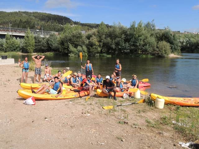 groupe d'ados se préparant à faire du canoe kayak en colo au Portugal