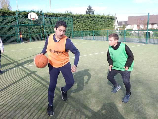 Enfants jouant au basket en colonie de vacances au printemps