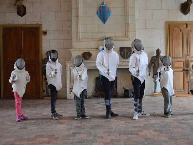 Groupe d'enfants en tenue d'escrime en colonie de vacances de printemps