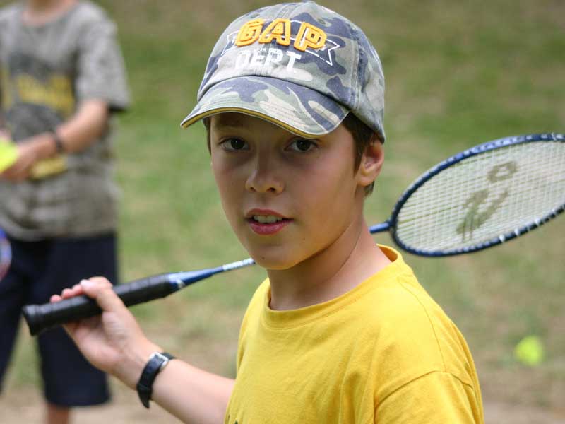 Portrait d'un jeune garçon faisant du tennis en colonie de vacances cet été
