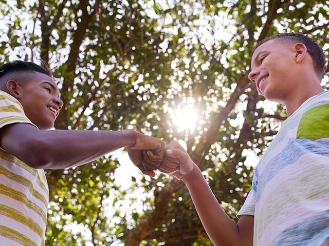 Deux jeunes garçons se disent bonjour en souriant lors d'une colo de vacances à Malte durant le printemps