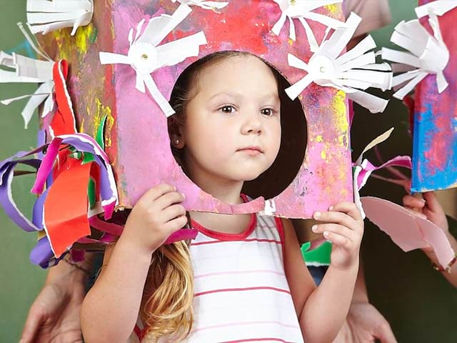 Jeune enfant avec un costume en carton fabriqué lors d'une colonie de vacances Artistes en herbe