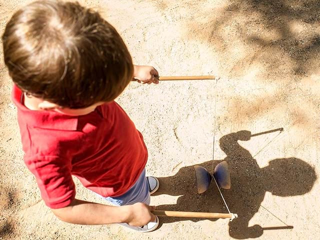 Vue sur un enfant qui fait du diabolo lors de sa colo de vacances Artistes en herbe