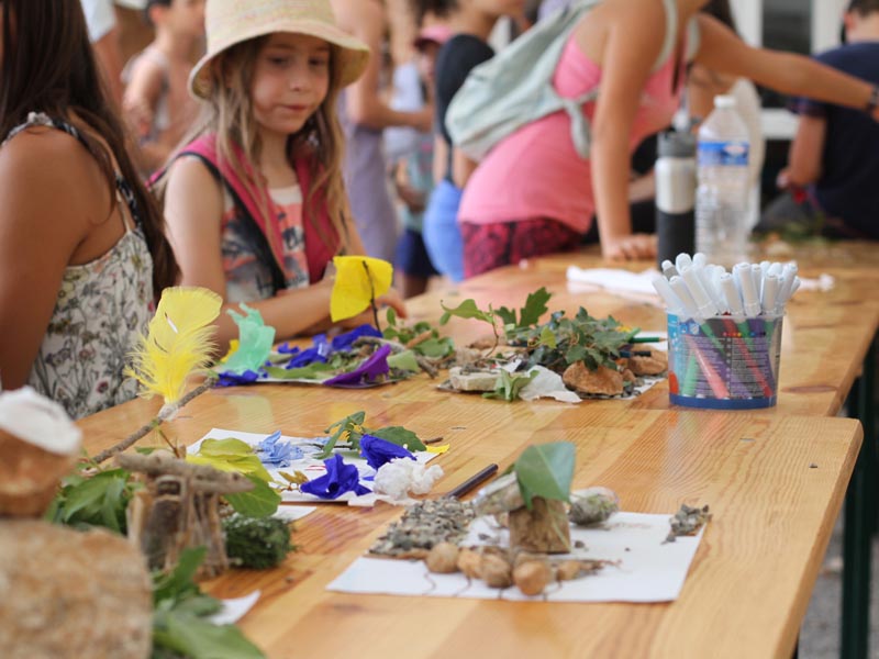 Enfants qui ont fait du land art et du bricolage avec des éléments naturels lors d'une colo de vacances Artistes en herbe