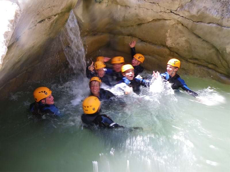 Des ados font du canyoning dans une rivière lors d'une colonie de vacances en Corse 