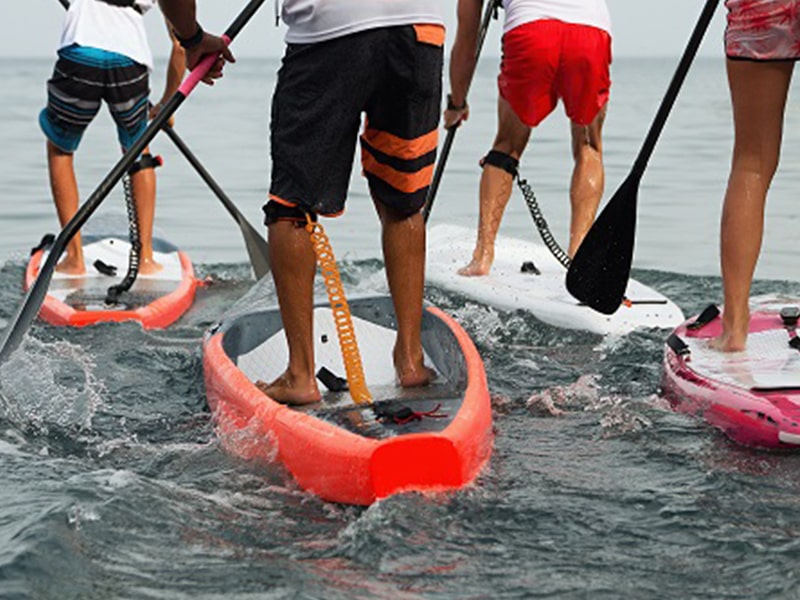 Les jeunes s'exercent au paddle lors d'une colonie de vacances en Corse durant le printemps