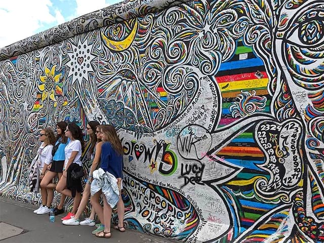 Rue colorée de street Art à Berlin avec les jeunes qui posent devant le mur