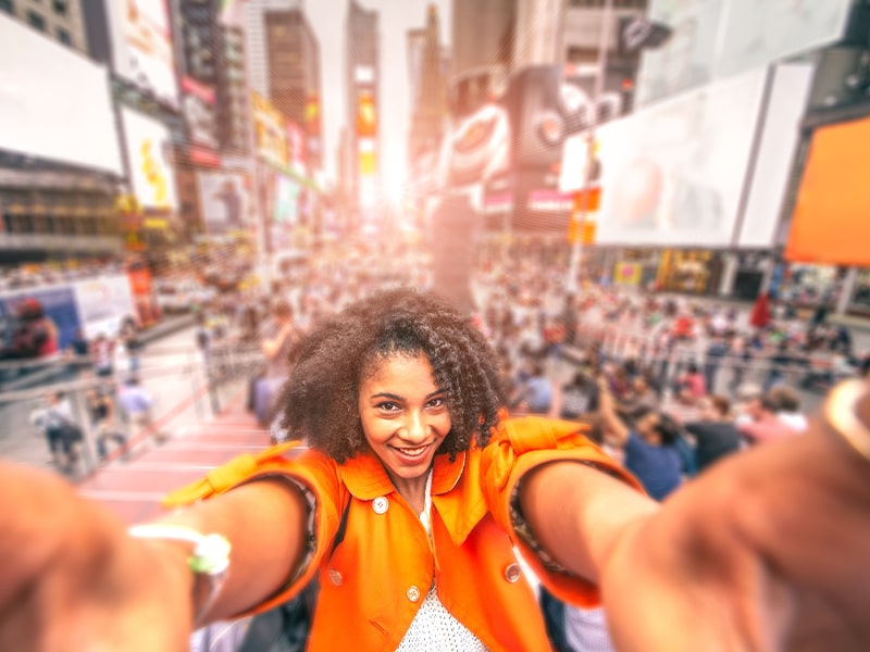 Vue sur une jeune fille qui se prend en photo devant une célèbre rue New-Yorkaise lors d'une colo de vacances au printemps