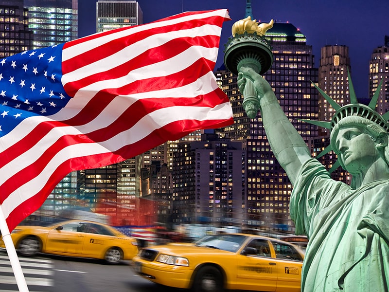 Vue sur la statue de la liberté, un taxi New-Yorkais et le drapeau américain lors d'une colo de vacances à New York