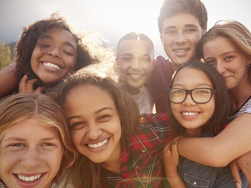 Groupe d'ados avec un grand sourire qui profitent de leur colonie de vacances à New York durant le printemps