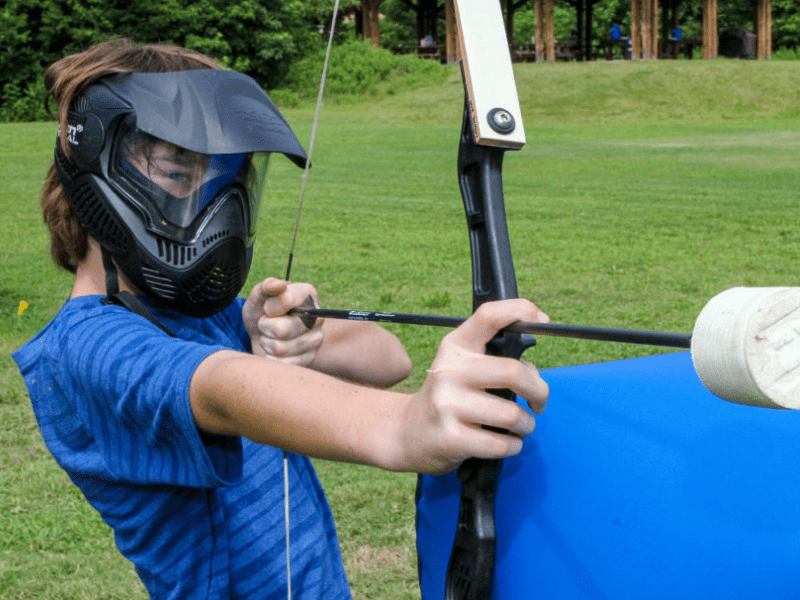 Jeune garçon qui s'exerce à l'Archery Tag en colonie de vacances à Pâques 