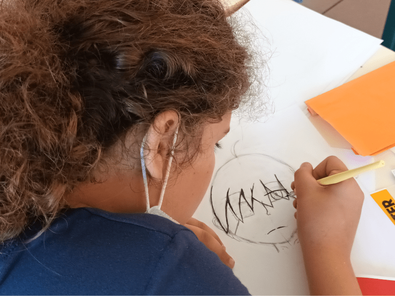 Jeune fille qui dessine un personnage de manga en colo artistique ce printemps