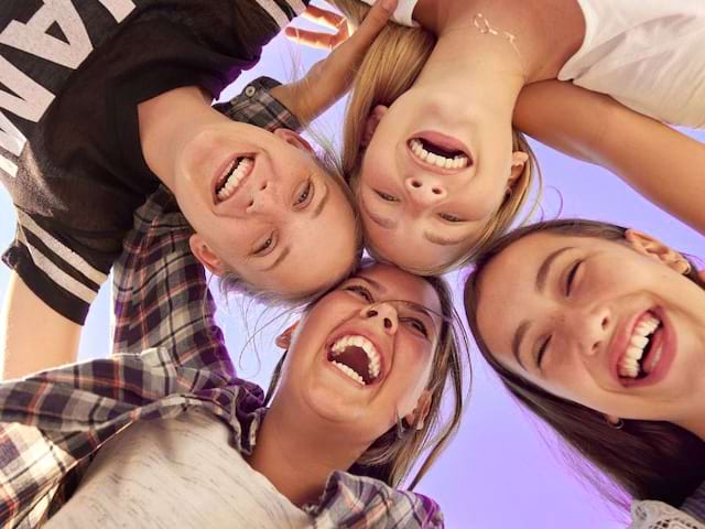 Groupe de jeunes filles qui sourient et s'amusent en colo de vacances au printemps