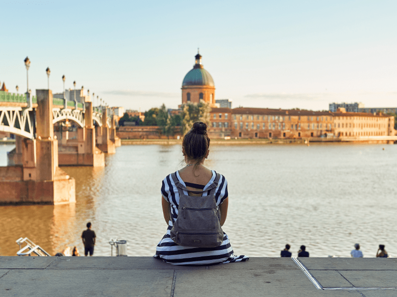 Jeune fille qui admire la vue sur le pont st pierre en colo de vacances à Toulouse