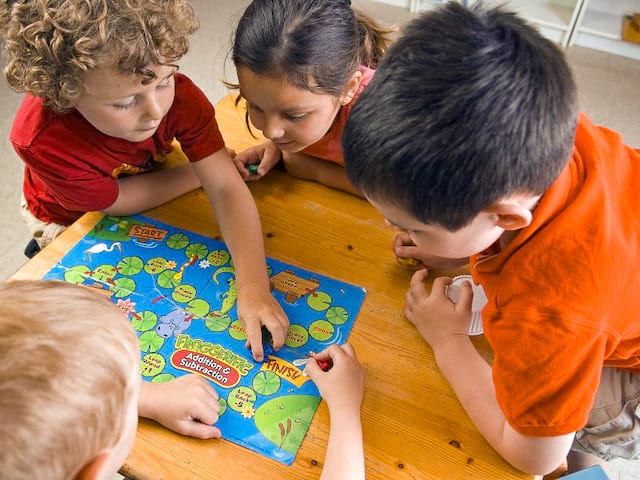 Enfants autour d'un jeu de société en colonie de vacances été